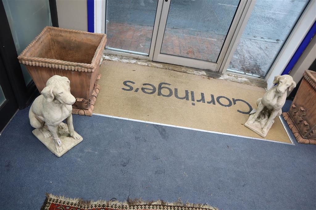A pair of reconstituted stone garden ornaments of seated hounds, height 70cm